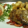 Marinerad entrecôte med stekt potatis, bacon, paprika, brunsås och sallad.