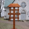 Detta vackra träsnindade och nytillverkade år 2010 står vid kyrkans ingång.