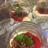Vit choklad panna cotta med fläder likör hallon och hyvlad mörk valrona choklad och citronmeliss serveras i syltburkar