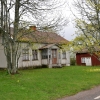 Mellan det tomma huset och staketet finns ingången, man kan ana grinden