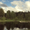 den mycket trevliga badplatsen på geråbadet med badbrygga, i bakgrunden ser man en del av de 10 stug