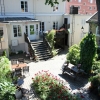 Vandrarhemsgården sett från värdbostaden. Entré gör du via trappan. Foto: Jan Ekroth