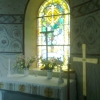 Altaret med krucifix. Korets östfönster med glasmålning.