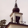 Tornet kröns av lökkupol vilket bryter av den i övrigt rena klassicistiska kyrkan