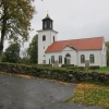Kyrkans framsida mot huvudingången och parkeringen samt församlingsgården.