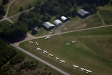 på bilden syns Sjöbo flygklubbs klubbstuga och hangarer samt privata hangarer