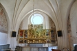 Tyvärr ger det runda lilla korfönstret starkt motljus och förtar skönheten i altarskåpet