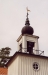 Tornet kröns av lökkupol vilket bryter av den i övrigt rena klassicistiska kyrkan