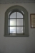 Ett fönster som vätter in mot angränsande rum ger ett milt sken i vapenhuset